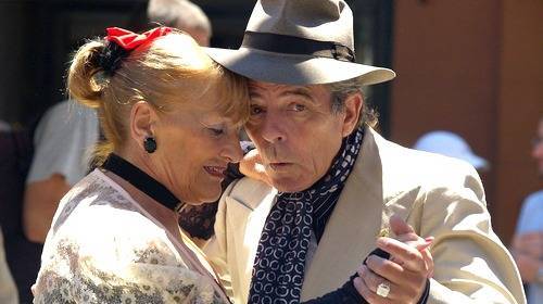 older man and woman dancing outside